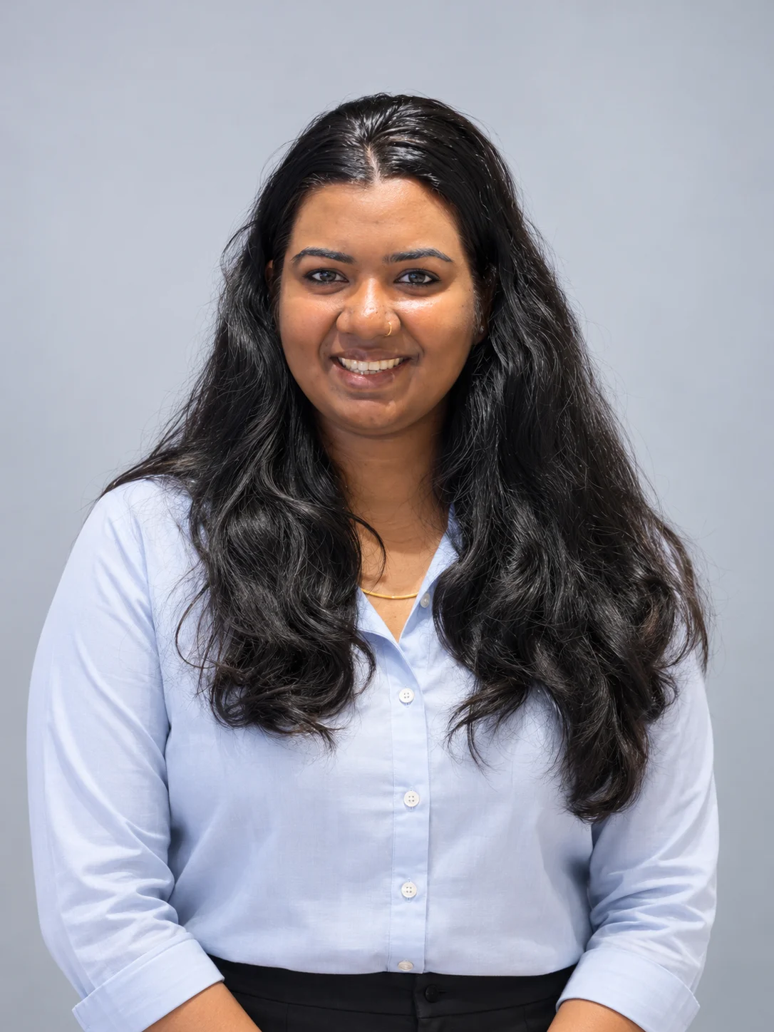 Haritha Devadas, smiling, in a light blue shirt